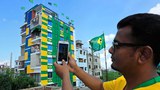 নারায়ণগঞ্জের ফতুল্লায় ব্রাজিল ভক্ত জয়নাল আবেদিন নিজের ছয় তলা বাড়ি ব্রাজিলের পতাকার রঙে রাঙিয়ে নাম দিয়েছেন ‘ব্রাজিল বাড়ি’।