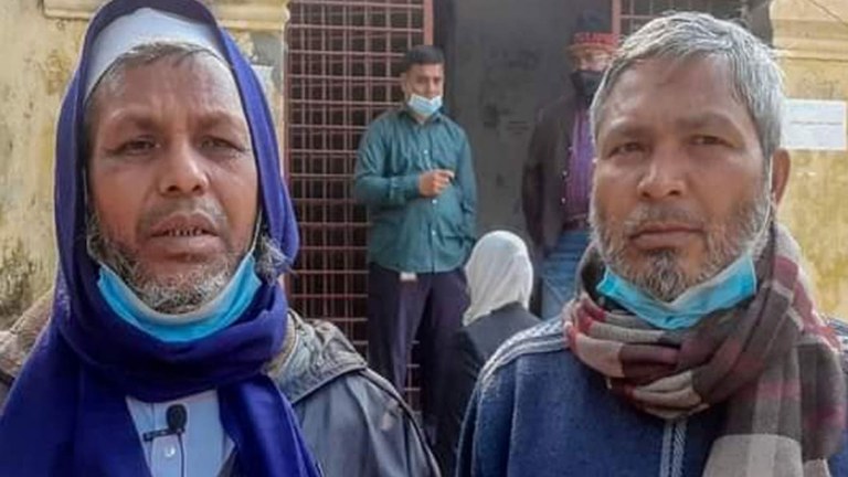 রাজশাহীর আদালত প্রাঙ্গণে দণ্ডপ্রাপ্ত চাঁপাইনবাবগঞ্জের গোমস্তাপুর উপজেলার বৈরতলা দাখিল মাদ্রাসার সুপার মোহা. আব্দুস সালাম (বামে) ও সহকারী শিক্ষক গোলাম কবির। ০১ ফেব্রুয়ারি ২০২২। [বেনারনিউজ]