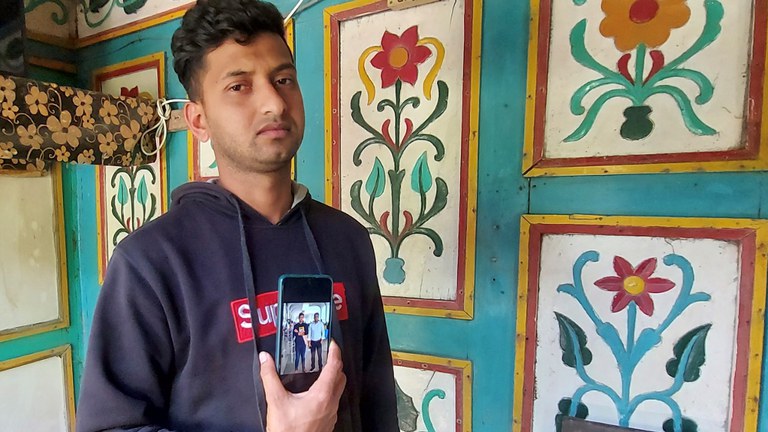 বরগুনার কদমতলা উপজেলার বেতাগী গ্রামে নিজের মোবাইল ফোনে ইউক্রেনে রকেট হামলায় নিহত নাবিক হাদিসুর রহমানের ছবি দেখাচ্ছেন নিহতের ভাই তারিকুল ইসলাম। ৩ মার্চ ২০২২। [বেনারনিউজ]