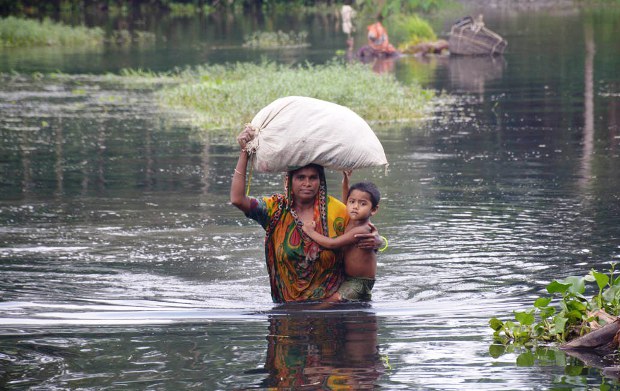 বন্যার পানিতে ঘরবাড়ি ভেঙে পড়ায় সন্তান নিয়ে আশ্রয়ের সন্ধানে ছুটছেন একজন মা। বন্যার পানিতে ঘরবাড়ি ভেঙে পড়ায় সন্তান নিয়ে আশ্রয়ের সন্ধানে ছুটছেন একজন মা।