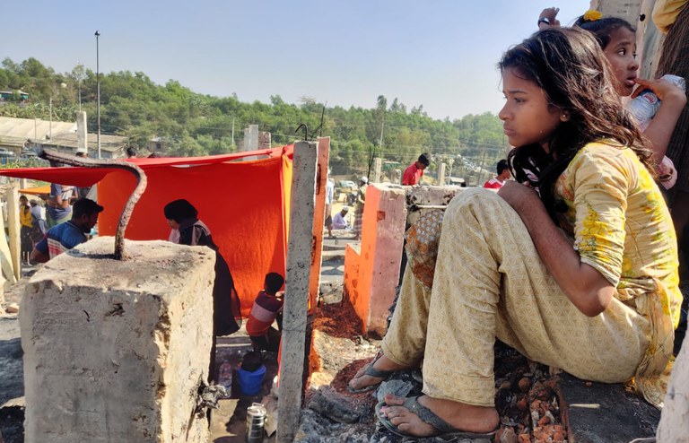 কক্সবাজার উখিয়ার পালংখালীর ১৬ নম্বর শরণার্থী শিবিরে আগুনে পোড়া ভিটায় বসে আছে এক রোহিঙ্গা কিশোরী। ১০ জানুয়ারি ২০২২। [আবদুর রহমান/বেনারনিউজ]
