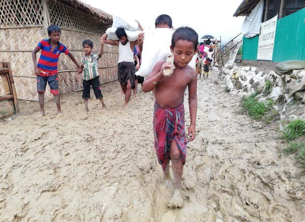 উখিয়ার মধুরছড়া শরণার্থী শিবিরে কাদামাখা পথ পেরিয়ে কাঁধে ত্রাণের বস্তা নিয়ে যাচ্ছে দুই রোহিঙ্গা শিশু। উখিয়ার মধুরছড়া শরণার্থী শিবিরে কাদামাখা পথ পেরিয়ে কাঁধে ত্রাণের বস্তা নিয়ে যাচ্ছে দুই রোহিঙ্গা শিশু।