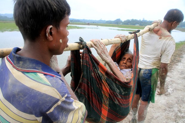 এক বৃদ্ধাকে কাঁধে বহন করে মিয়ানমারের রাখাইন রাজ্য থেকে পালিয়ে আশ্রয়ের সন্ধানে বাংলাদেশে প্রবেশ করছেন দুই রোহিঙ্গা শরণার্থী। এক বৃদ্ধাকে কাঁধে বহন করে মিয়ানমারের রাখাইন রাজ্য থেকে পালিয়ে আশ্রয়ের সন্ধানে বাংলাদেশে প্রবেশ করছেন দুই রোহিঙ্গা শরণার্থী।