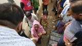 উখিয়ার পালংখালী এলাকায় সন্তান কোলে ত্রাণ নিচ্ছেন একজন রোহিঙ্গা নারী
