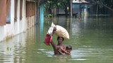 সন্তানকে নিয়ে ডুবে যাওয়া পথ পাড়ি দিয়ে আশ্রয়ের সন্ধানে ছুটছেন এক বাবা।