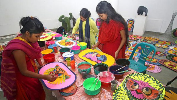 চারুকলায় মুখোশ তৈরিতে ব্যস্ত কয়েকজন শিক্ষার্থী। 