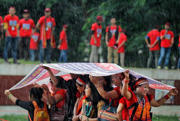 ঢাকায় বিশ্ব আদিবাসী দিবসের শোভাযাত্রা চলাকালে বৃষ্টি থেকে বাঁচতে একটি ব্যানার দিয়ে মাথার ছাদ তৈরি করে নিয়েছেন আদিবাসী নারীরা। ঢাকায় বিশ্ব আদিবাসী দিবসের শোভাযাত্রা চলাকালে বৃষ্টি থেকে বাঁচতে একটি ব্যানার দিয়ে মাথার ছাদ তৈরি করে নিয়েছেন আদিবাসী নারীরা।