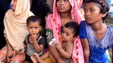 বৃষ্টির কারণে খোলা জায়গায় আশ্রয় নেওয়া এক রোহিঙ্গা পরিবার লেদা ক্যাম্পের ভেতরে একটি দোকানের পাশে বসে আছে।