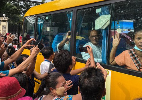 A crowd greets a bus carrying prisoners released from Insein Prison in Yangon, Myanmar, Nov. 17, 2022.