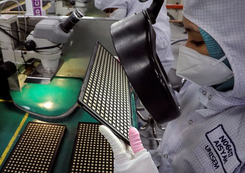 A worker inspects semiconductor chips at the Unisem (M) Berhad plant in Ipoh, Malaysia, Oct. 15, 2021.
