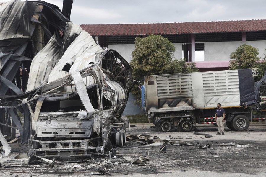 A Thai officer stands beside a burnt down oil tanker at a gas station in Pattani province after an overnight wave of arson and bomb attacks in Thailand’s southernmost provinces that authorities have blamed on Muslim separatist rebels, Aug. 17, 2022.