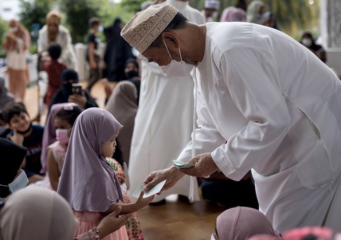 A child receives money following morning prayers at The Foundation of the Islamic Center of Thailand mosque during Eid al-Fitr celebrations, marking the end of the Muslim holy month of Ramadan, in Bangkok, May 2, 2022.