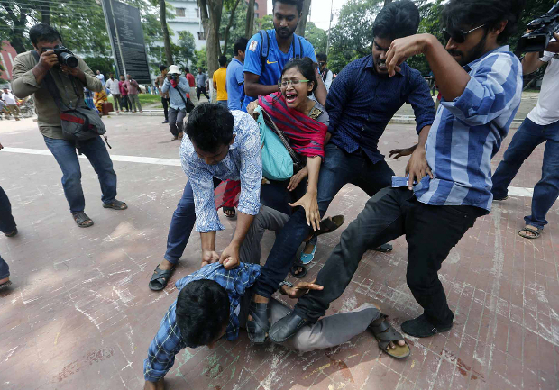 A Bangladeshi man protesting in favor of reforms to quotas for civil service jobs is attacked by counter-demonstrators in Dhaka, July 2, 2018. [BenarNews]
