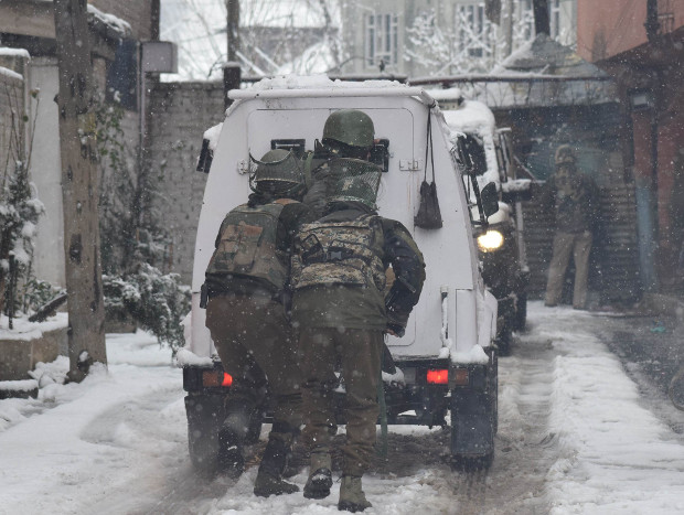 Paramilitary security personnel hide behind a bullet-proof vehicle during a gunfight with suspected LeT militants near their camp in Srinagar, Feb. 12, 2018.  [Sheikh Mashooq/BenarNews] 