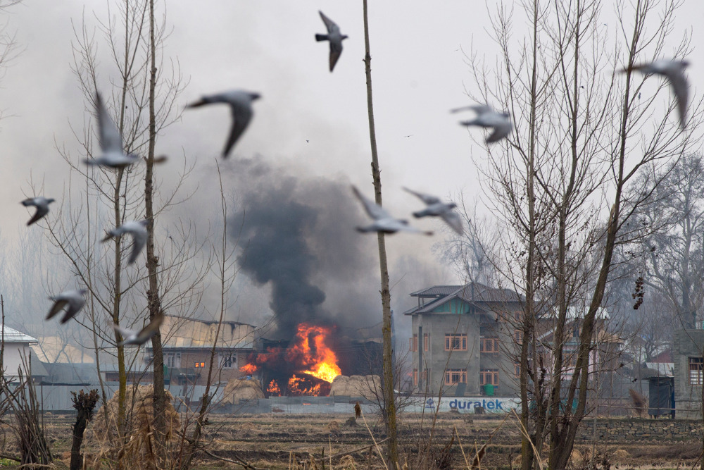 Smoke billows from a burning residential building where suspected militants took refuge during a gunbattle with government forces in Pulwama, a district of Indian-administered Kashmir, Feb. 18, 2019. [AP] 