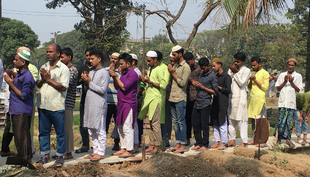 People pray near the graves of victims of the fire in Old Dhaka at the Azimpur Cemetery in Dhaka, Feb. 22, 2019. [Megh Monir/BenarNews] 