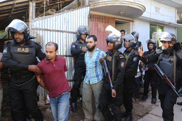 Members of the Rapid Action Battalion arrest suspected members of a banned extremist group in Chittagong, now officially known as Chattogram, Dec. 8, 2016. [AFP]