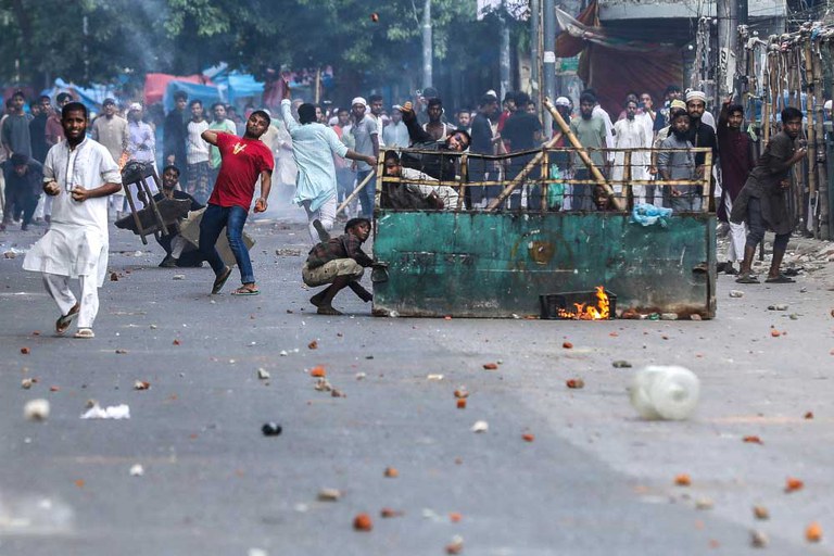 Demonstrators throw stones as they clash with police during the ongoing anti-quota protest in Dhaka, July 19, 2024. [Abu Sufian Jewel/AFP]