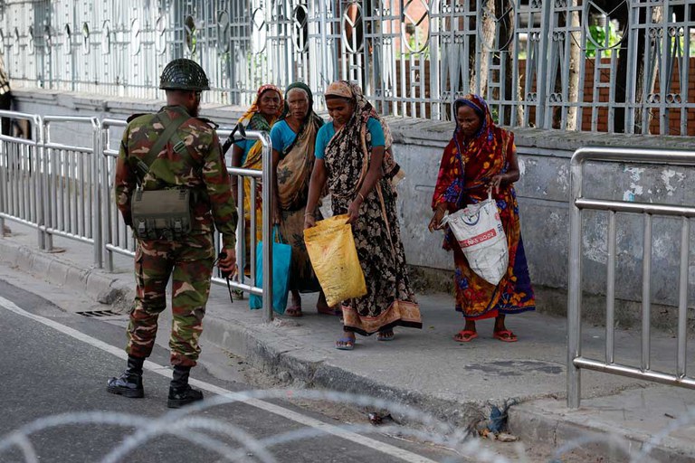 A member of the Bangladesh Army checks bags of women during a curfew imposed in response to student-led protests against government job quotas, in Dhaka, July 20, 2024. [Mohammad Ponir Hossain / Reuters]