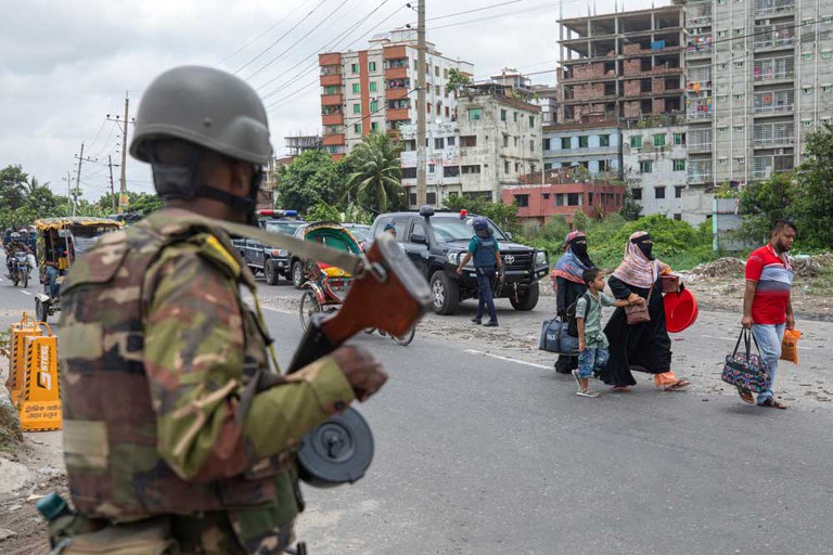 Bangladesh police inspect a motorcyclist’s bag during a traffic stop in Dhaka on the fourth day of curfew imposed by the government, July 23, 2024. [Rajib Dhar/AP]