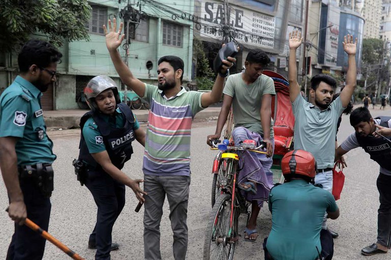 Police in Dhaka frisk commuters during a curfew imposed following days of anti-quota protests throughout Bangladesh, July 21, 2024. [Anik Rahman/AP]