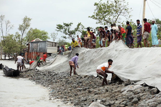 Residents of Satkhira district in southwestern Bangladesh repair a dam damaged by Cyclone Amphan, May 21, 2020. [BenarNews]