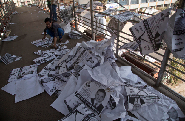 A Bangladeshi man collects election posters in Dhaka, a day after the ruling coalition won almost every seat in parliament through the country’s 11th general election, Dec. 31, 2018. [AP]