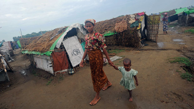 A Rohingya woman and her child walk in front of tents at the Mansi IDP camp, on the outskirts of Sittwe in western Myanmar's Rakhine state, May 15, 2013. (AFP)