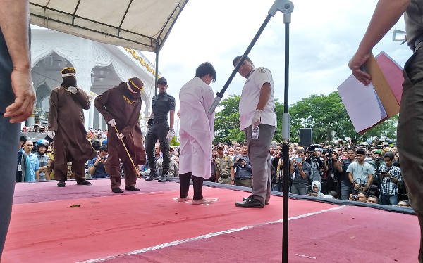 A medic checks on a man undergoing caning after being convicted of gay sex in Banda Aceh, Indonesia, May 23, 2017.  