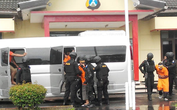 Police load six suspected militants into a van in Malang, East Java, Feb. 21, 2016. 