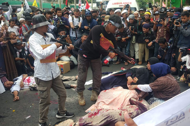 Protestors perform a theatrical depiction of alleged torture of Uyghur Muslims during a demonstration outside the Chinese embassy in Jakarta, Dec. 21, 2018. [Rina Chadijah/BenarNews]