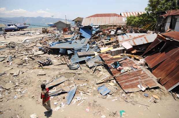 A man walks near collapsed homes in Wani II village of Donggala Regency, days after a powerful earthquake and a tsunami struck Central Sulawesi province, Oct. 2 2018. [Keisyah Aprilia/BenarNews]