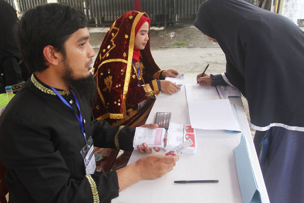 A woman checks in to vote at a polling station in Padang, West Sumatra, June 27, 2018. [M. Sulthan Azzam/BenarNews]
