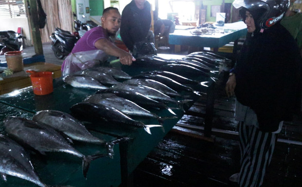 A fishmonger (left) sells fish to a customer at a market in Ranai, in Indonesia’s Natuna regency, Dec. 6, 2019. [Nosa Normanda/BenarNews]  
