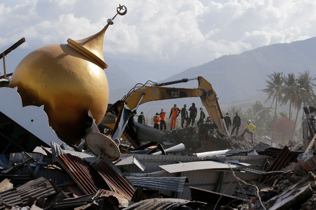 Rescuers stand beside a toppled mosque in the earthquake-hit Balaroa neighbourhood of Palu, Central Sulawesi, Oct. 6, 2018. [AP] 