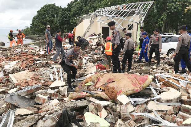 Police take part in a search for tsunami victims amid collapsed building in Pandeglang regency, Banten province, Dec. 24, 2018. [Keisyah Aprilia/BenarNews]