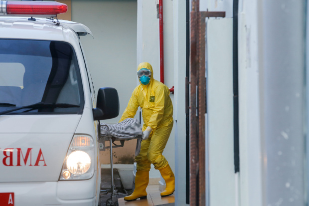 A medical worker dressed in protective gear pulls a gurney from an ambulance at Sanglah Hospital in Bali, Indonesia, March 11, 2020. [Reuters]