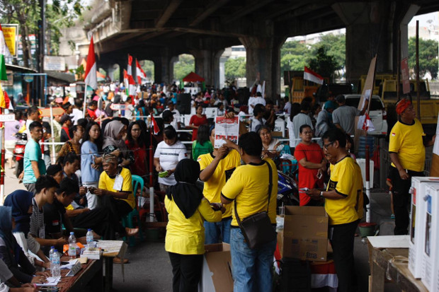 Jakarta residents watch election workers counting votes under a bridge in North Jakarta, April 17, 2019. (Keisyah Aprilia/BenarNews)