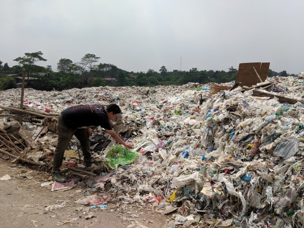 A man picks through plastic packaging in a dumpsite for imported plastic trash, in Bekasi, in Indonesia’s West Java province, May 16, 2019. [Ahmad Syamsudin/BenarNews]