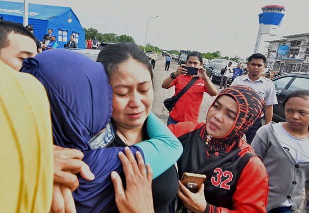 Putri (center), a woman whose husband and child were on board the crashed Lion Air flight, is consoled at Pangkal Pinang airport in Bangka Belitung province, Oct. 29, 2018. [AFP]