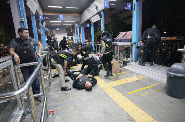 Police assist their colleagues who suffered injures during the clash with protesters in front of the of the Election Supervisory Agency headquarters in Jakarta, May 22, 2019. [Keisyah Aprilia/BenarNews]