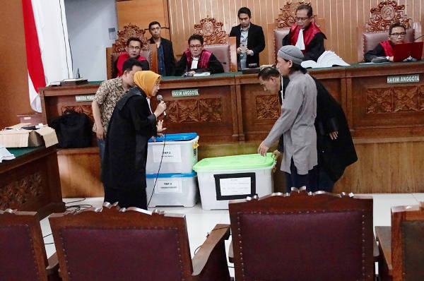 Prosecutor Mayasari (left) shows the books written by Aman Abdurrahman (right) at the South Jakarta Court, April 27, 2018. 