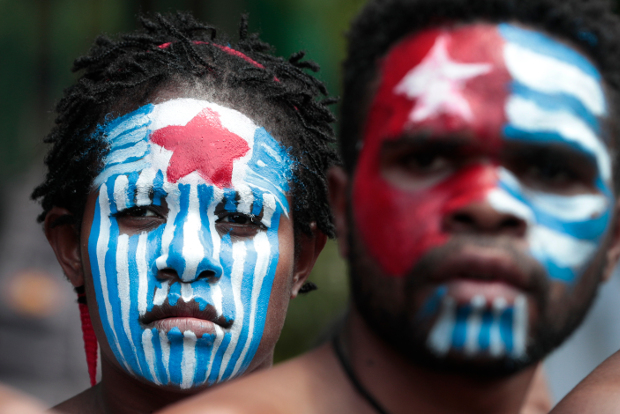 Papuan activists, their faces painted with the colors of the separatist Morning Star flag, attend a rally near the presidential palace in Jakarta, Aug. 22, 2019. [AP]