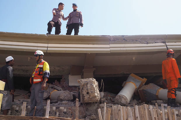 Rescue workers search for survivors in the rubbles of a building that pancaked after powerful earthquake struck North Lombok in Indonesia’s West Nusa Tenggara province, Aug. 7, 2018. [Anton Muhajir/BenarNews]