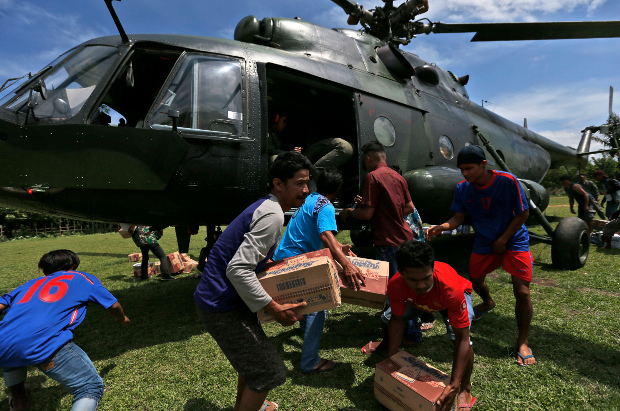 Earthquake survivors carry relief goods delivered by an Indonesian Army helicopter in Poroo, Central Sulawesi, Oct. 7, 2018. [AP]