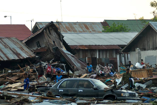 Residents try to salvage belongings from homes which collapsed after earthquakes and a tsunami hit Palu, Sulawesi on Sept. 29, 2018. [AFP]