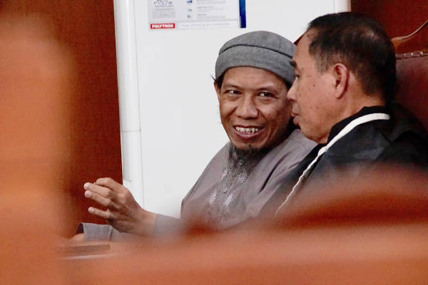 Aman Abdurrahman (left), talks to his lawyer during a hearing in the South Jakarta District Court, April 28, 2018. [Arie Firdaus/BenarNews]