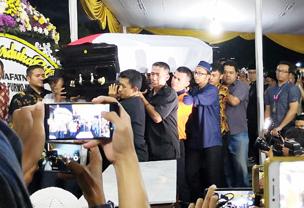 Mourners carry the casket of Sutopo Purwo Nugroho into a funeral home in East Jakarta, July 7, 2019. [Tia Asmara/BenarNews]