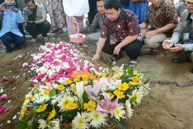 Muhammad Ivanka Rizaldy Nugroho prays at his father’s grave, July 8, 2019. [Kusumasari Ayuningtyas/BenarNews]