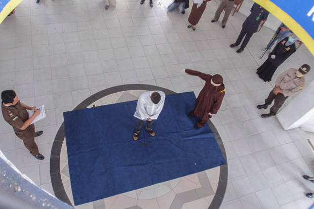 A man found guilty of violating Sharia law in Aceh province, Indonesia, is caned, April 21, 2020. [Ahyar/BenarNews]